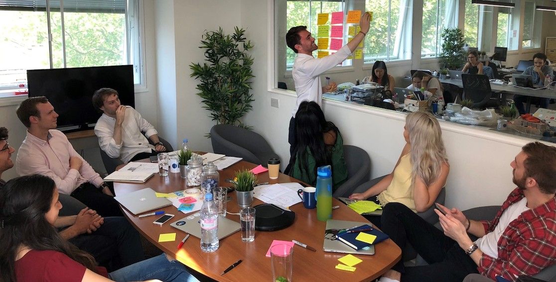 some mmtm developers at a desk in the background behind a mmtm-branded mug