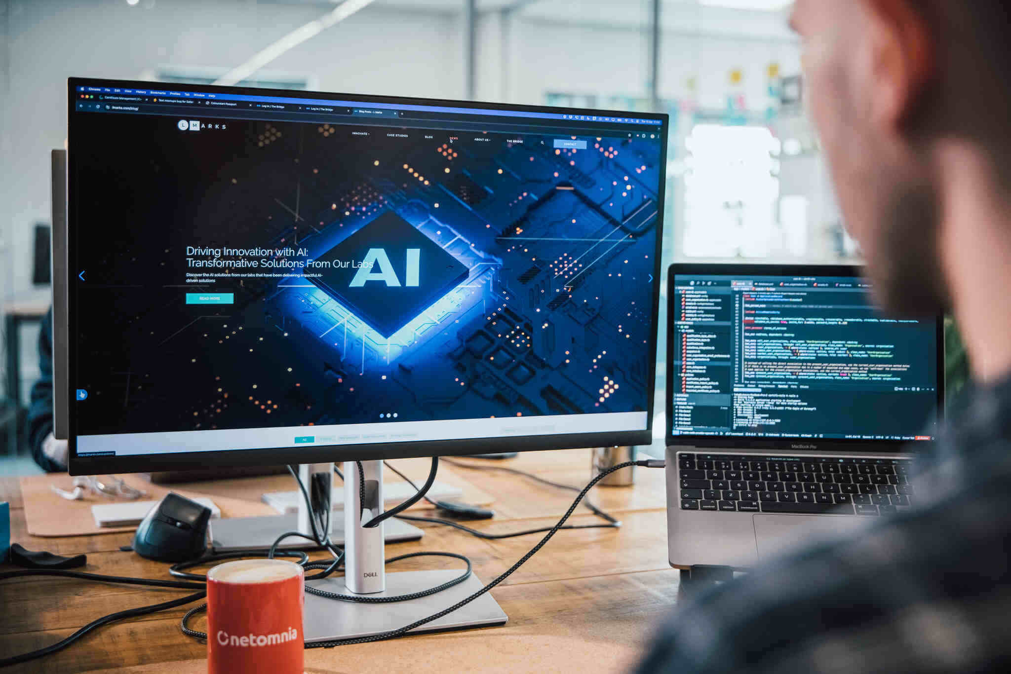 mmtm developer working with AI tools on a monitor and laptop